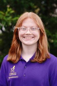 Photo of Rylee Keasler wearing a purple Orientation Leader polo shirt.