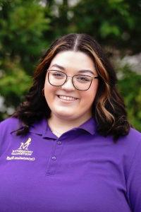 Photo of Jordan Long wearing a purple Orientation Leader polo shirt.