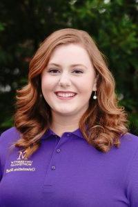 Photo of Bella Macomb wearing a purple Orientation Leader polo shirt.