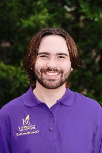 Photo of Christian Tooley wearing a purple Orientation Leader polo shirt.