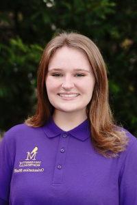 Photo of Kylee VanNostrand wearing a purple Orientation Leader polo shirt